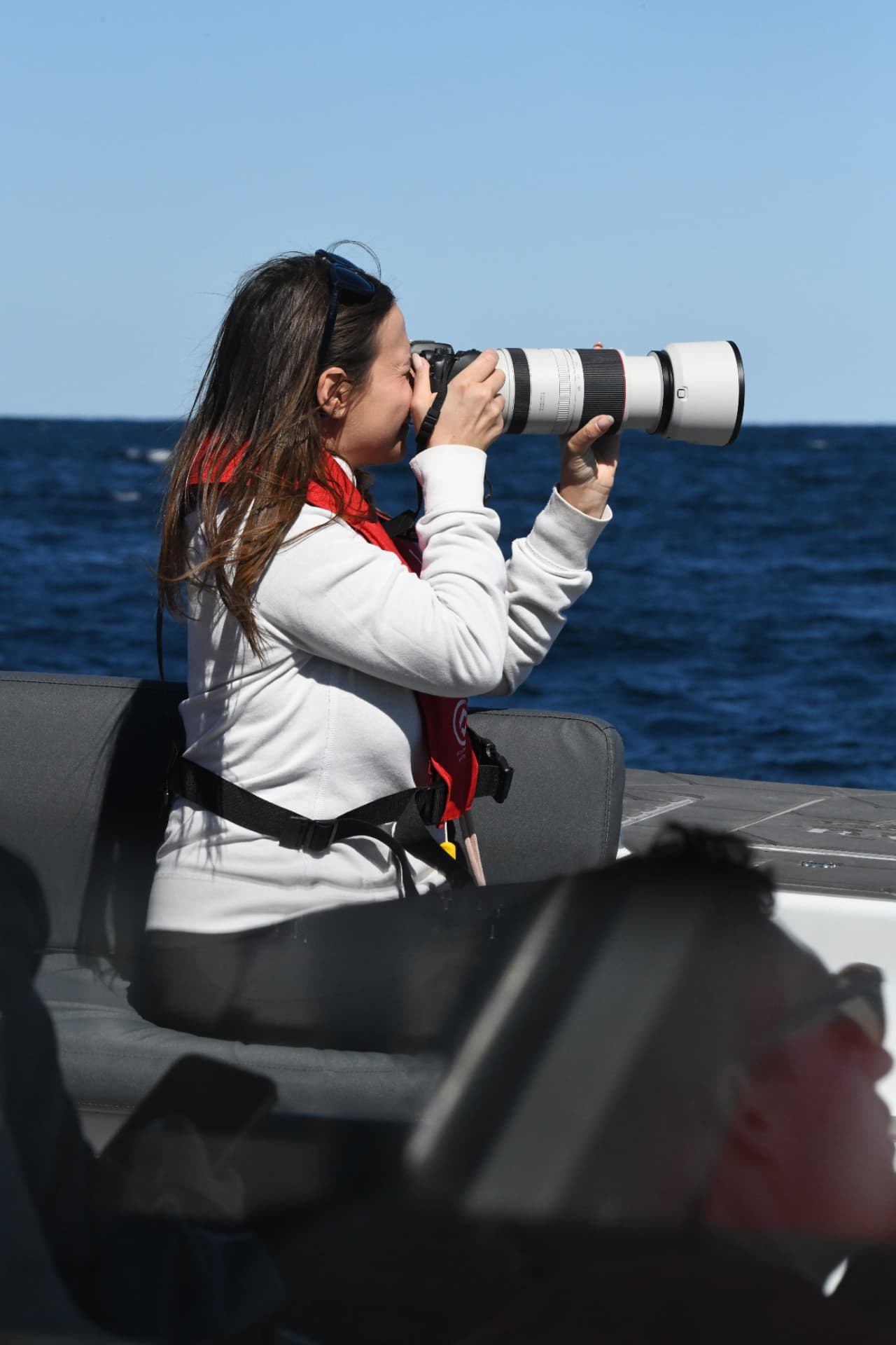 Guest shooting whales with a long telephoto lens from the deck of Cetacean One